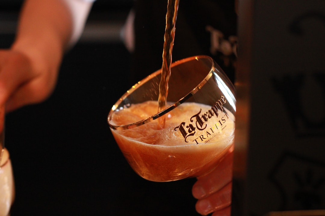 a person pouring a drink into a glass