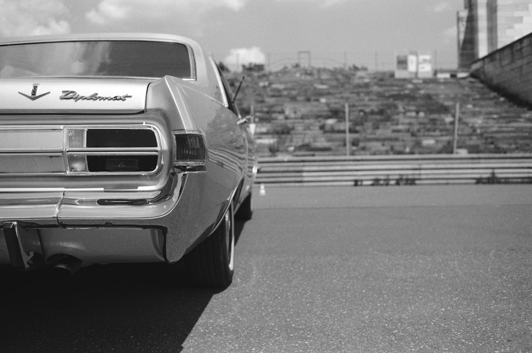 a black and white photo of a car parked on the side of a road