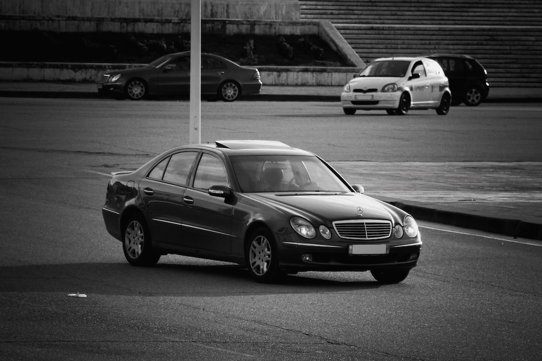 grayscale photo of mercedes benz sedan on road