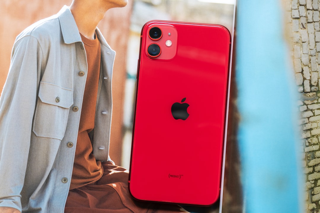 man in brown button up shirt holding red iphone 7 plus