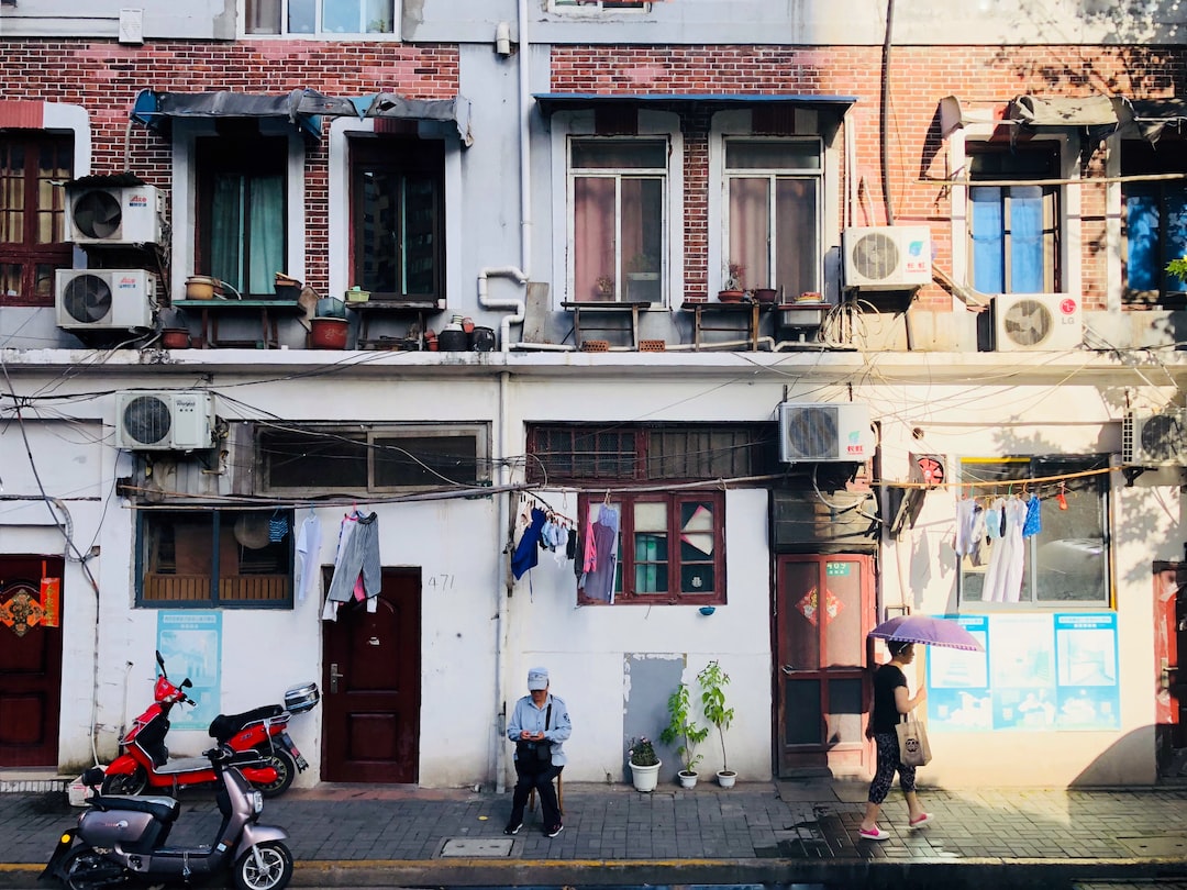 man and woman walking beside houses