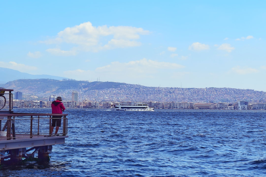 man in red shirt sitting on red boat during daytime