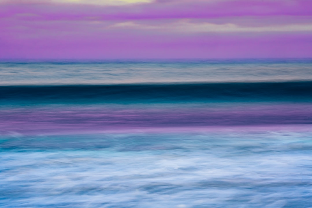 blue ocean water under cloudy sky during daytime