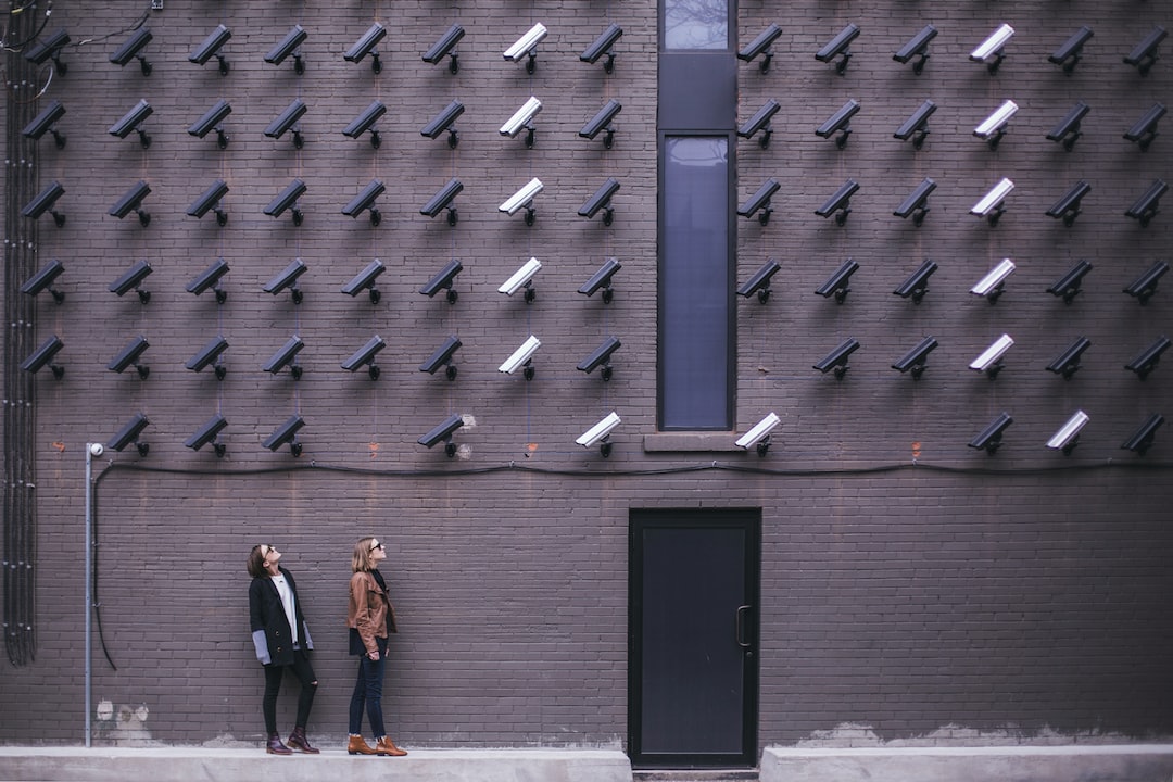 two women facing security camera above mounted on structure