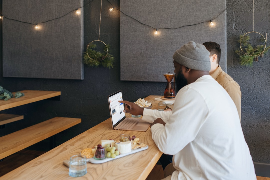 Two people collaborating on their Surface laptop sitting on a table at work