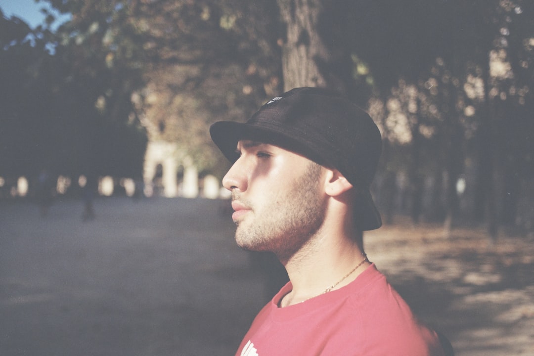 a man with a hat standing in a park