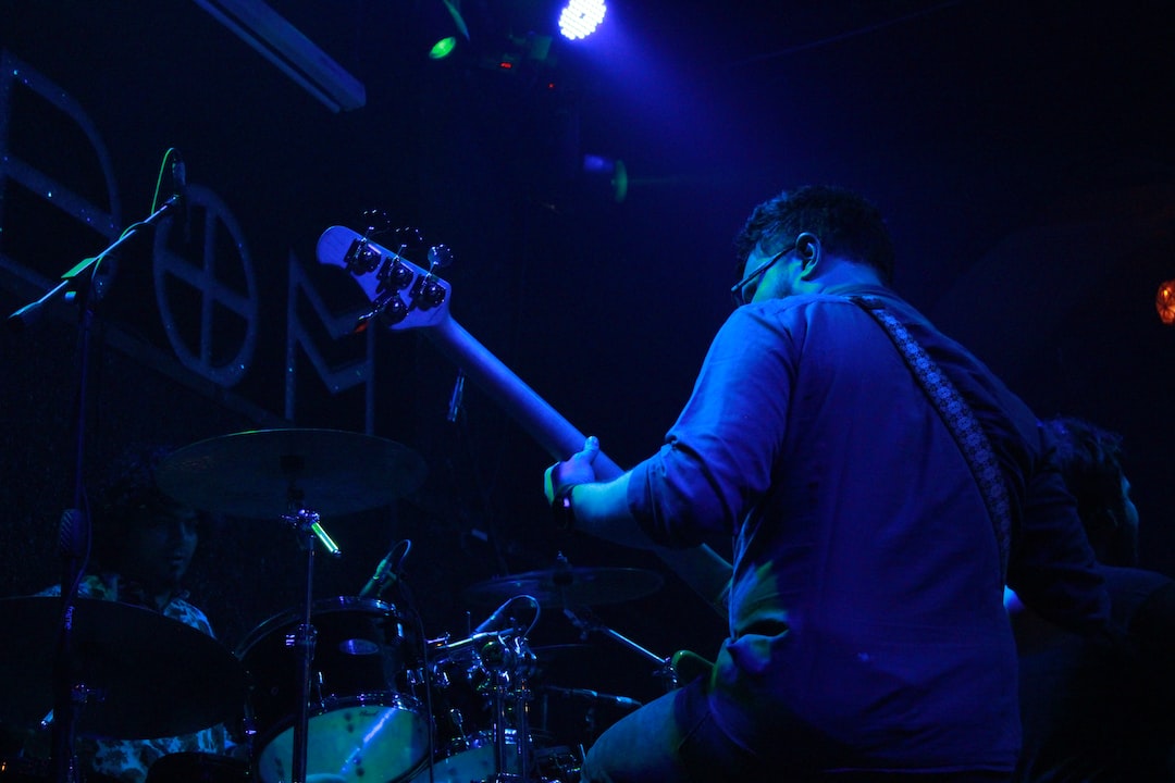 a man playing a guitar in a dark room