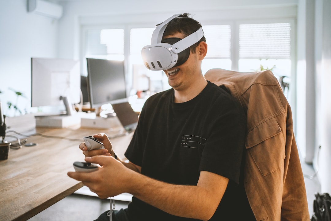 a man sitting at a desk wearing a virtual reality headset