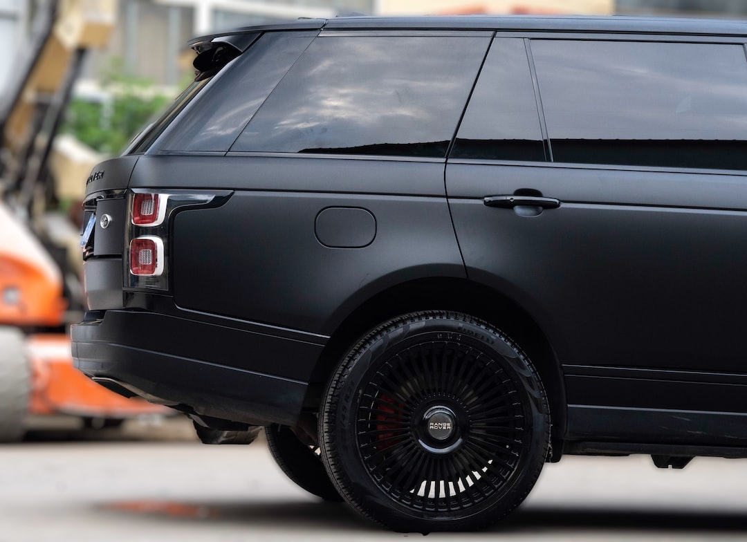 a black range rover parked in front of a building