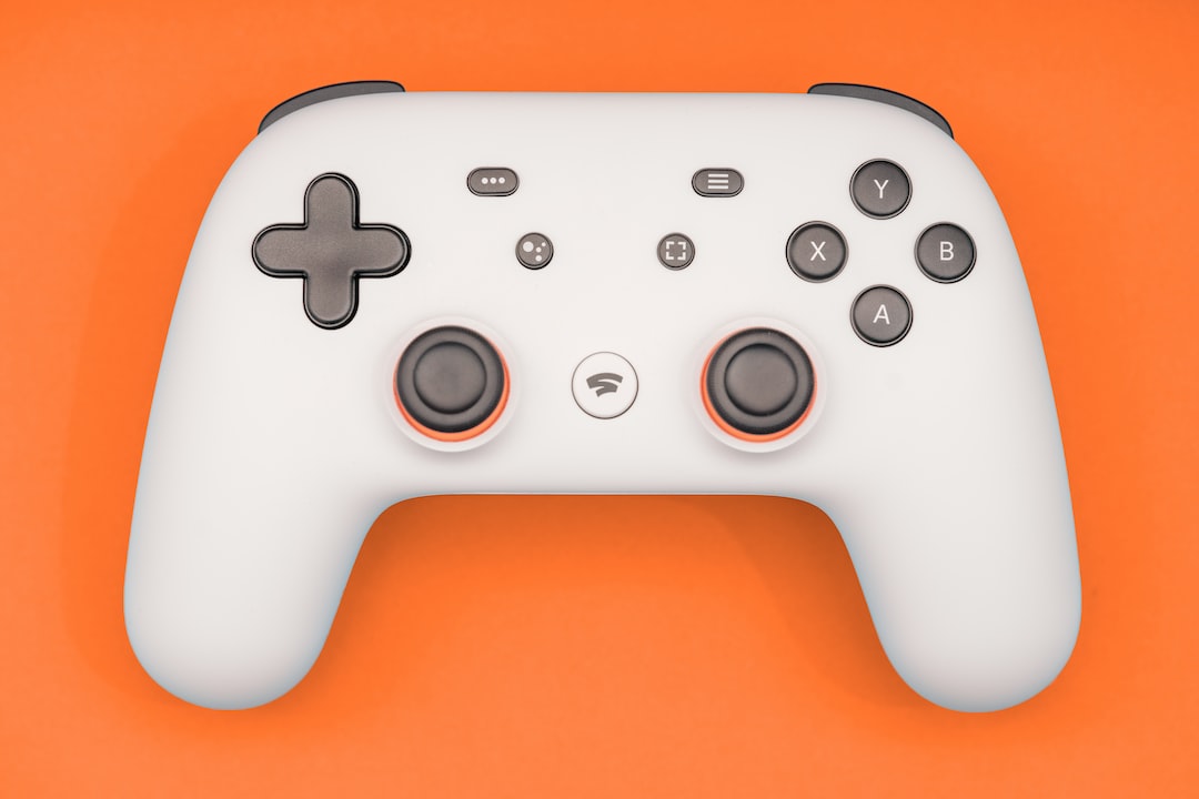 a close up of a white controller on an orange background