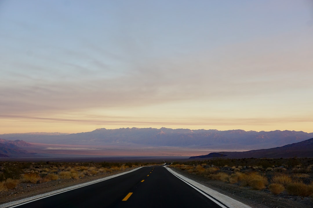 black road under cloudy sky