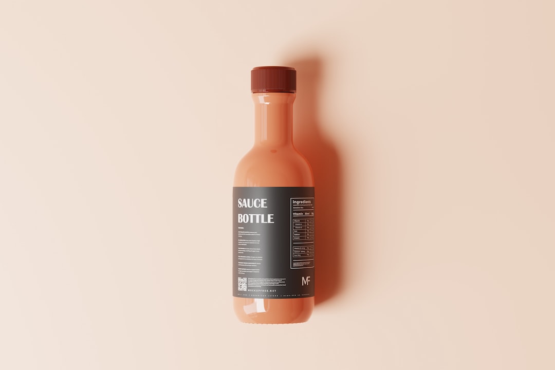 a bottle of sauce on a pink background