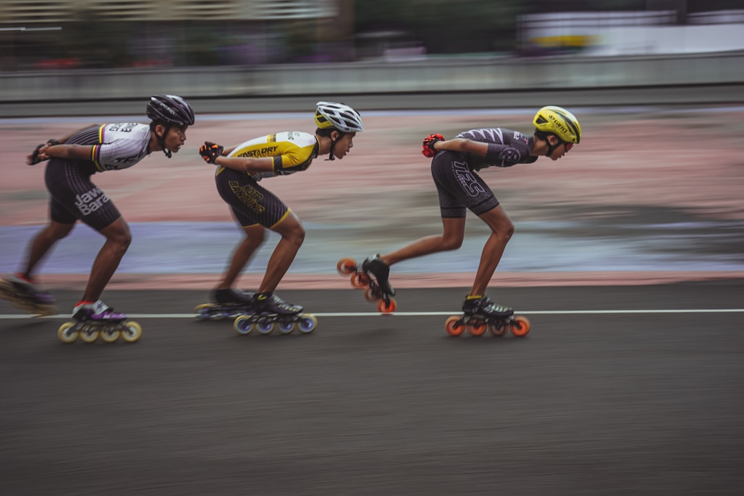 man in blue tank top and yellow helmet riding on orange and black motorcycle