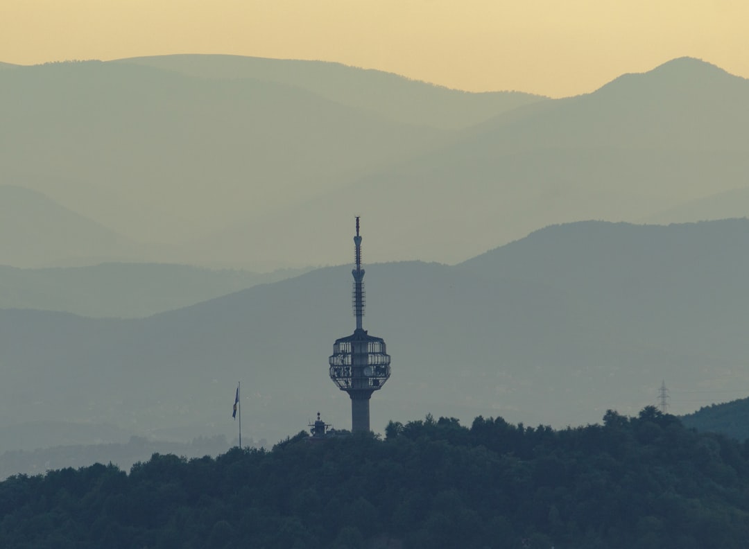 a tower on top of a hill with a mountain in the background