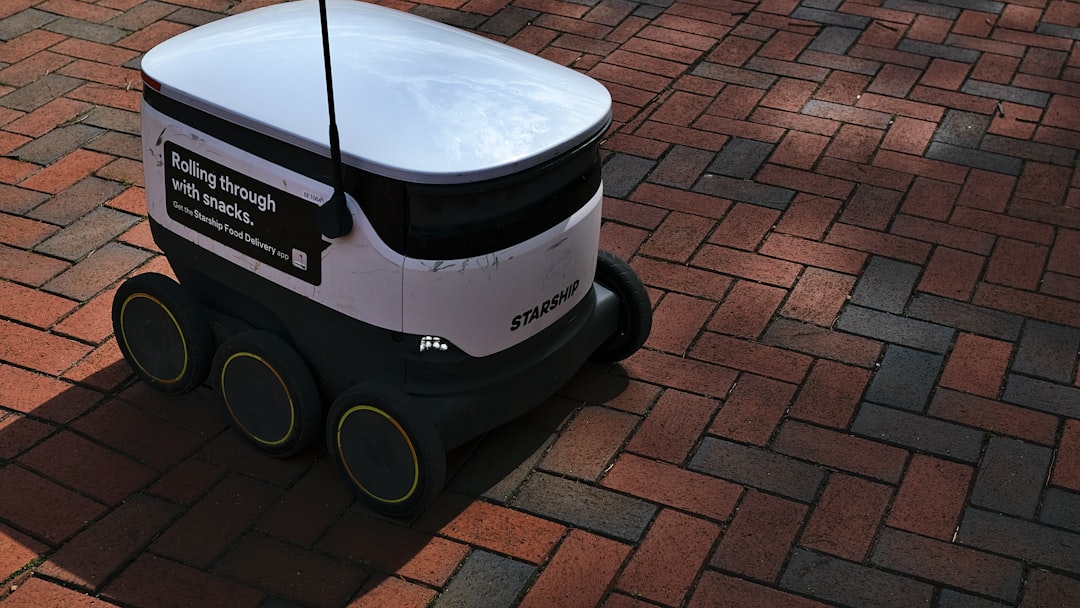 a white and black robot sitting on top of a brick road