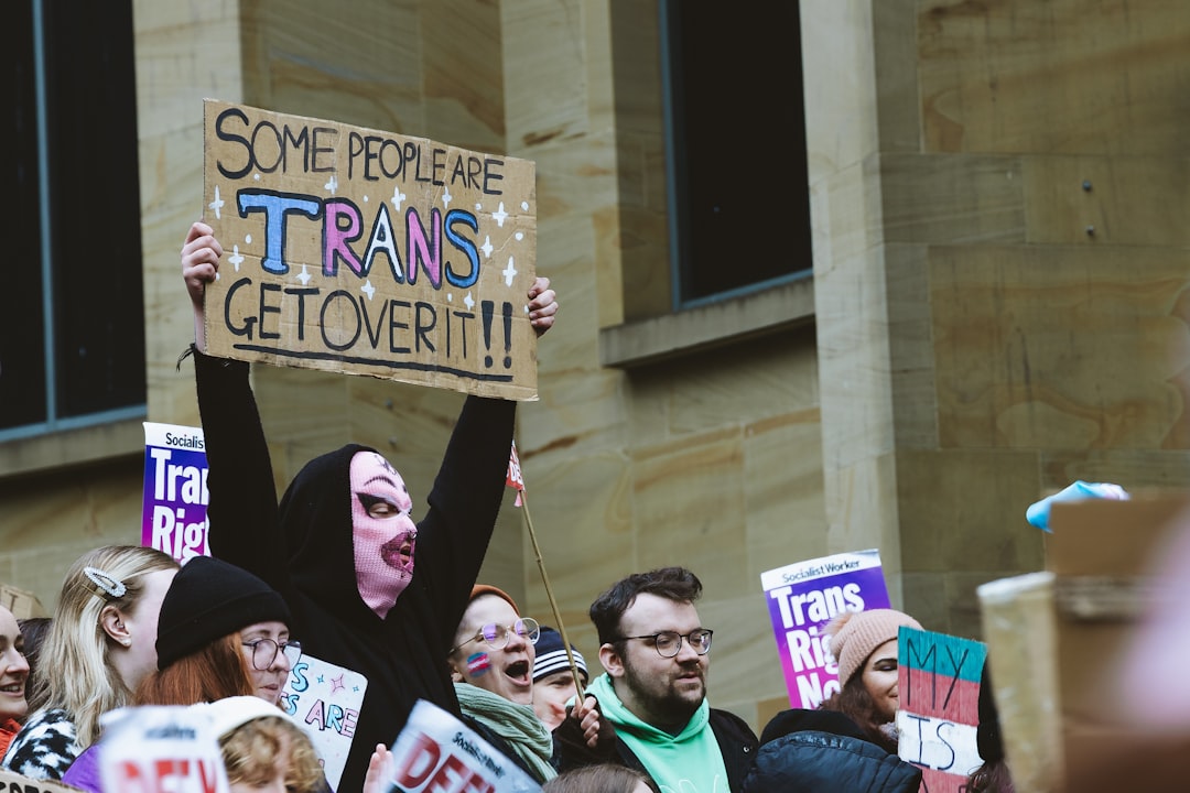 a crowd of people holding signs and wearing masks