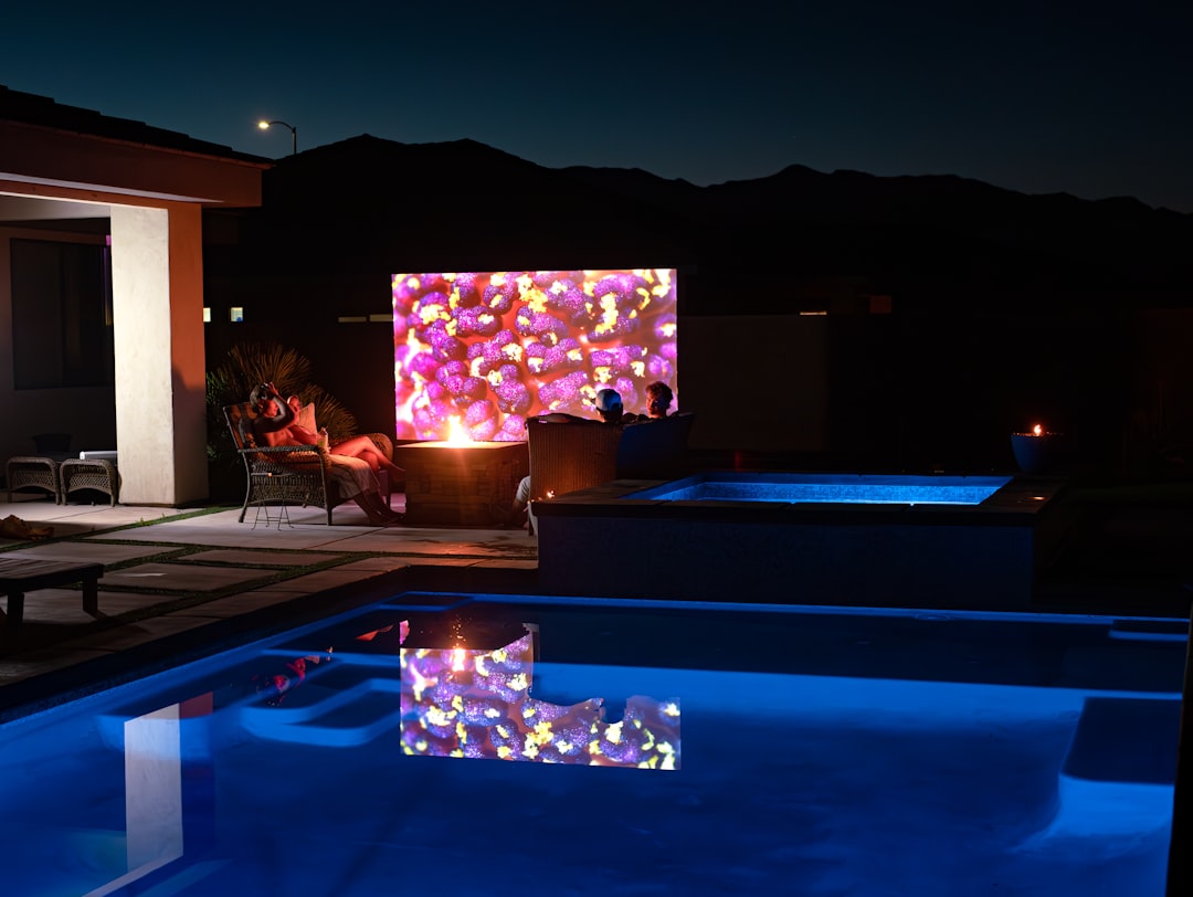 A pool at night with lights reflecting off of the water