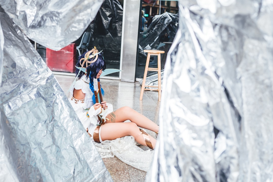 a woman sitting on the ground in front of a building