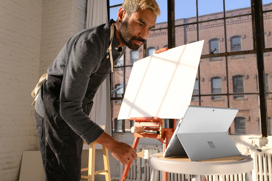 a man standing in front of a laptop computer