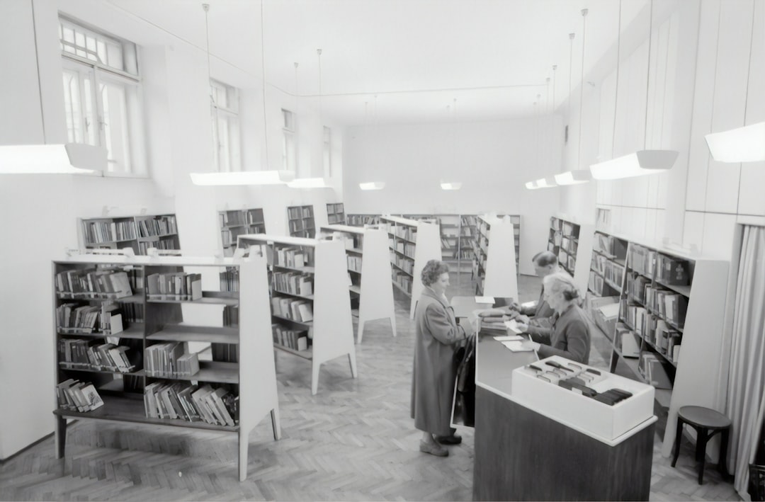 grayscale photography of people inside book store