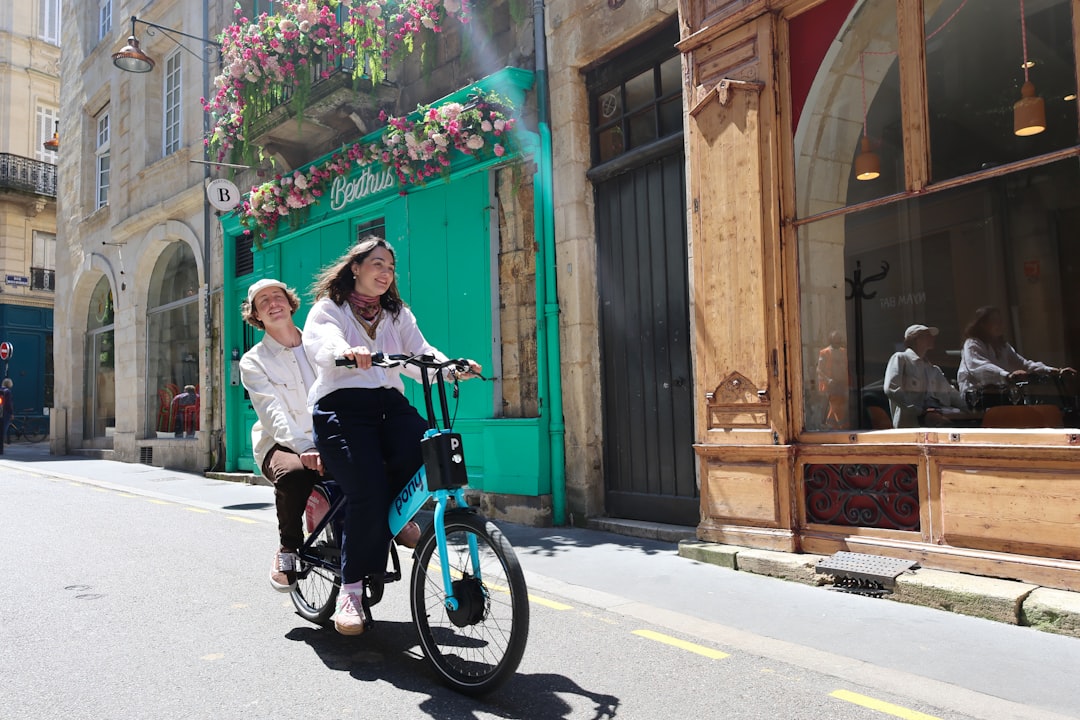 a woman riding a bike next to a woman in a white shirt