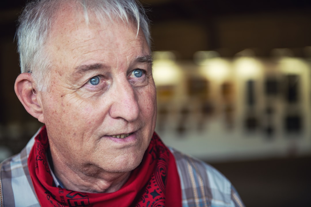 man in red scarf and blue and white plaid shirt