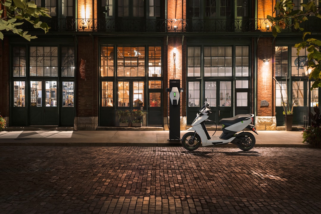 black and white motor scooter parked beside brown building