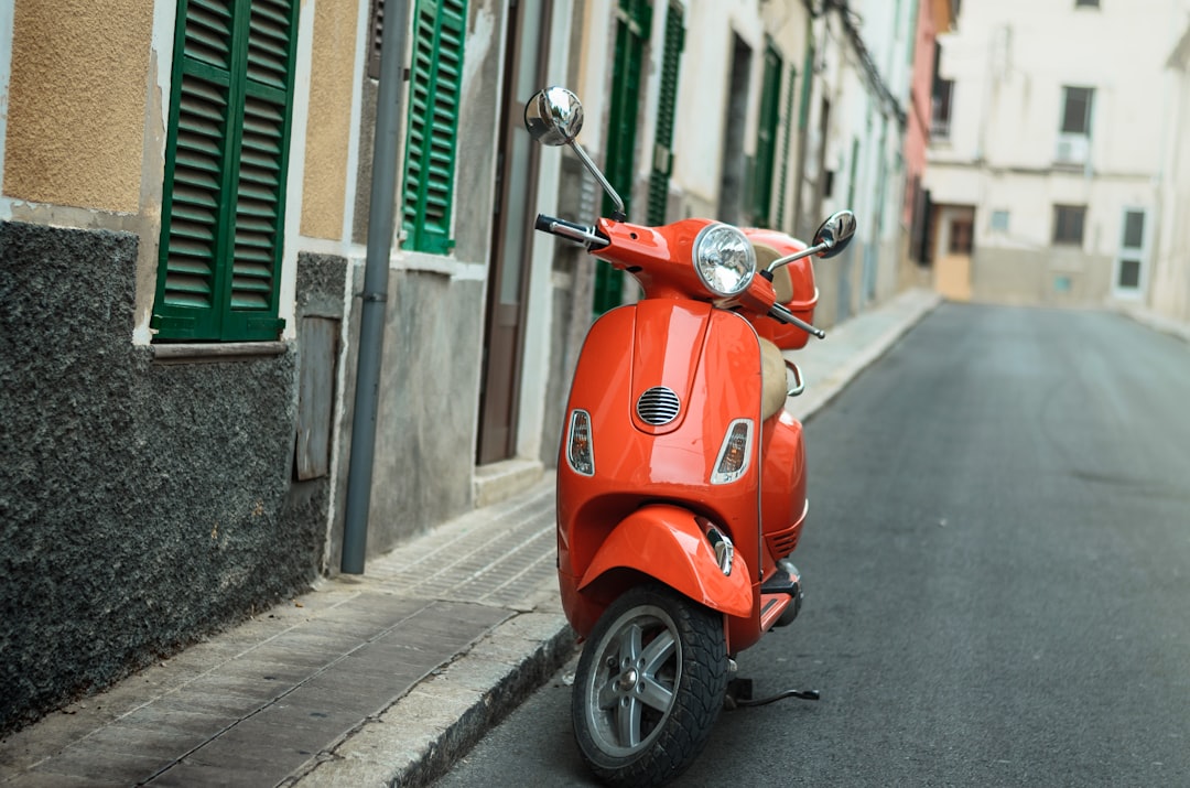 red motor scooter on street during day time