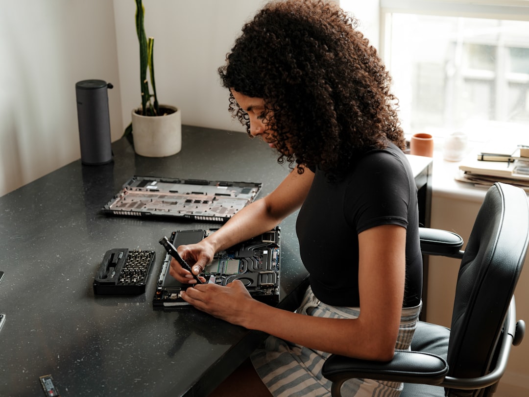 A woman sitting at a desk using a cell phone