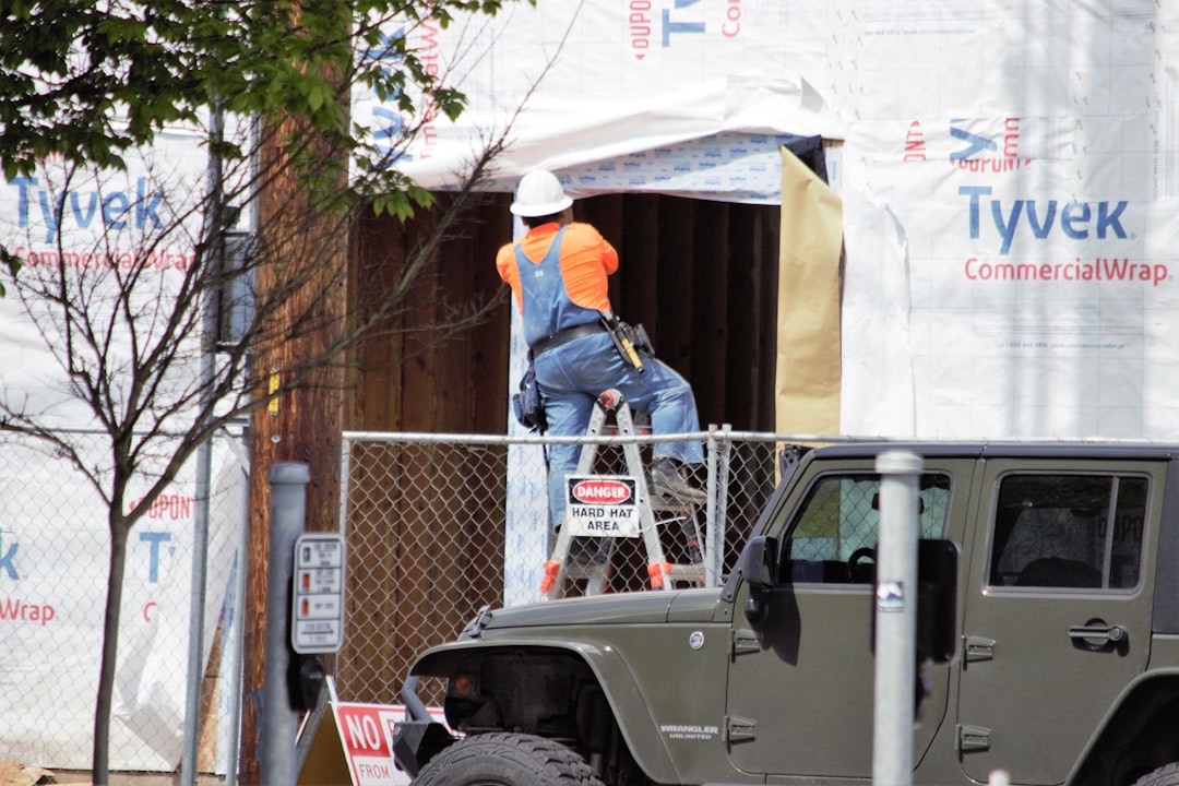 a man on a ladder working on a jeep